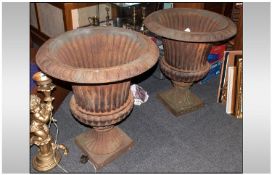 Large Pair Of Cast Iron Garden Urns of Campagna shape with a rubbed fluted body, terminating on a