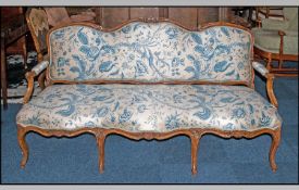 Edwardian Three Seater Walnut Framed Salon Sofa, of shaped form with carved floral decoration.