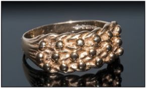 A 9ct gold Textured Keeper Ring with hallmarks for London 1989, 4.3grams.