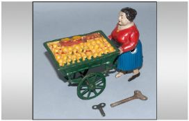 Unusual German Clockwork Composition & Tin Toy Figure Of A Street Vendor pushing her cart, selling