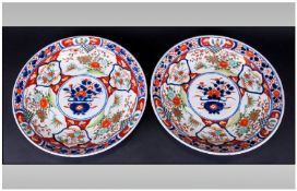 Pair of Imari Chargers a band of polychrome vignettes around the central roundel showing a vase of