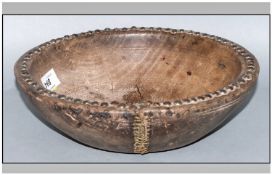 A Middle Eastern Antique Wooden Mixing Bowl with studs applied to the outer rim. 11`` in diameter.