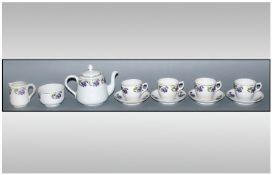 Dolls Porcelain Teaset comprising teapot, four cups and saucers, milk jug and sugar bowl. Purple