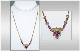 A 14ct Gold Set Ruby & Diamond Necklace the seven tear drop shaped rubies spaced between 41