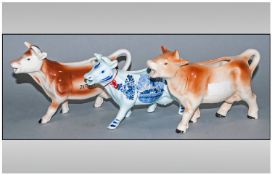 Three Cow Creamer Ceramic Figures comprising Jersey, Delft Blue and one other. 4 inches high.