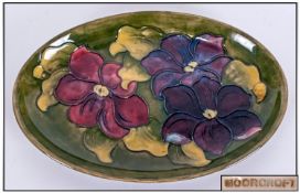 Moorcroft Oval Shaped Shallow Bowl, `Clematis` Pattern on green ground. Overall good condition. 9``