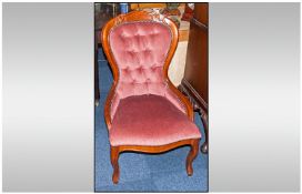 Teak Framed Nursing Chair with Pink Upholstered Button Back Cushion.