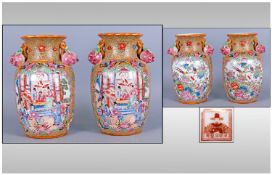 Pair Of Chinese Famille Rose Style Vases depicting figures in a courtyard setting. 9" in height