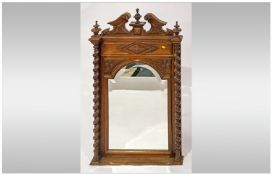 Victorian Carved Walnut Framed Wall Mirror, with a carved scroll pediment top & barley twist columns