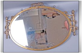 Edwardian Oval Brass Wall Mirror Of Unusual Design, to the sides a torch baton motif in cast