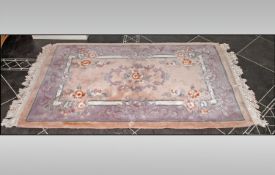 Chinese 100% Wool Rug, predominantly peach in colour with mauve decoration. 70 by 38 inches.