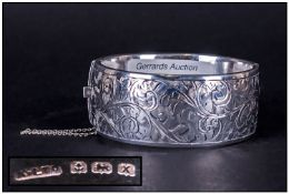 A Good Quality Silver Hinged Bangle with engraved decoration and safety chain. Hallmark Birmingham