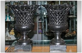Pair Of Unusual Cast Iron Basket Weave Urns, terminating on a square schole base. 14" in height.