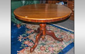 A Round Mahodany Victorian Loo Table, with a turned central pedestal, on three shaped cabriole legs.