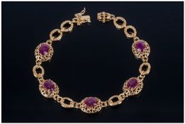 Ruby Station Bracelet comprising oval cut rubies, individually set in decorative mounts, interspaced