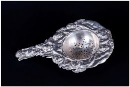 Victorian Fine Silver Embossed & Ornate Tea Strainer decorated with figures of Putti to borders.