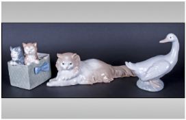 Three Nao by Lladro Figures comprising goose, kittens in basket and box, various heights.