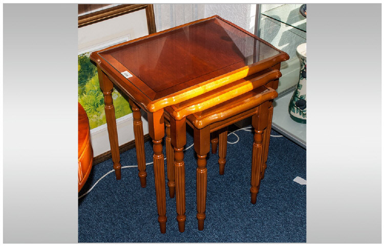 Nest Of Three Coffee Tables, yew wood in traditional style. Fitted glass tops on reeded round legs.