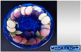 William Moorcroft Footed Shallow Bowl, 'Lemons' Pattern on blue ground. 7.25" in diameter.