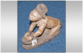 Carving of a Yoruba Woman kneeding dough, ready for cooking. Wearing a typical hair style of this