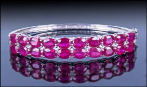 Ruby and White Topaz Bangle, two rows of oval cut rich red rubies, enhanced with small round cut