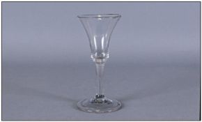 A George III Clear Wine Glass with a trumpet shaped bowl on a plain stem with spreading circular