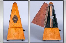 A Piano Metronome in a Wooden case. Plaque to front reads MAELZEL PAQUET  1815-1846.
