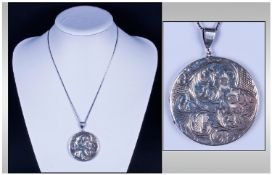 A Large Silver Circular Locket with chased floral decoration to front. 1.75`` in height. Hallmark