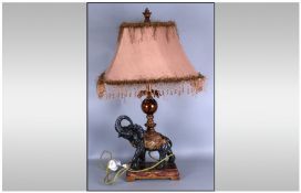 Bronzed Resin Lamp Base In The Form Of An Elephant, with a glass centre piece column on its back,