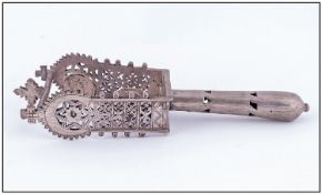 An Unusual Hand Religious Rattle Of Low Grade Silvered Metal, the sides engraved and reticulated in