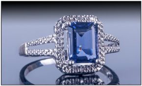 Ladies 9ct White Gold Dress Ring, Set with a central square shaped sapphire surrounded by a row of