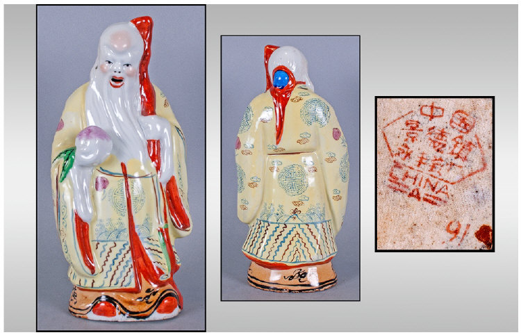 Chinese Famile Rose Figure Of Shoulao Holding A Staff, decorated in bright yellow enamels. Unglazed