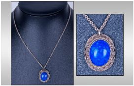 Oriental White Metal Pendant, set with a central lapis coloured stone with wire work border,