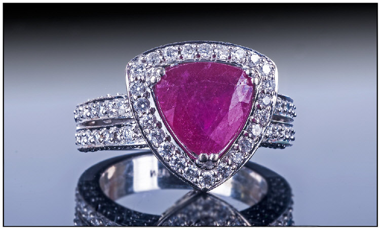 14ct White Gold Ruby And Diamond Ring, set with a trillion cut ruby surrounded by round cut