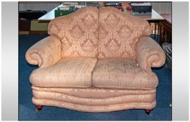 A Classic Design 2 Seat Sofa in Pale Pink upholstery brocade with loose cushions.
