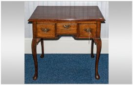 George III Oak Lowboy With Overhanging Top, above three drawers with shaped apron, raised on
