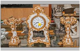 A Gilded Resin 3 Piece clock set in the French style consisting of a pair of four branch candle