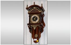 A Dutch Freishland Style Brass Hanging Wall Clock on two brass weights the clock is supported by a