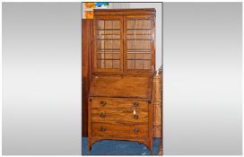 An Edwardian Oak leaded top Bureau Bookcase, with a full front fitted interior, on bracket feet