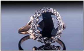 Ladies 9ct Gold Dress Ring, Set with an oval shaped central dark sapphire surrounded by surrounded