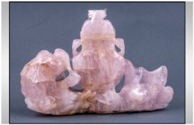 A Chinese Rosequartz Carving Of A Reclining Dragon holding a loft a lidded vase. with defects. 5``