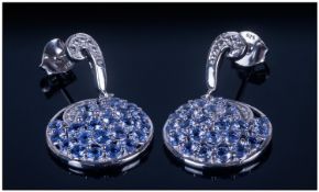 Tanzanite Circular Drop Earrings, a cluster of tanzanites in a platinum and silver circular setting