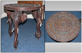 Anglo-Indian Carved Table, the circular top profusely engraved with floral scroll engravings, the