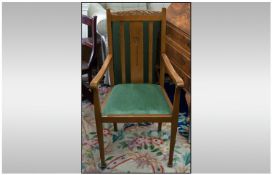 An Oak Edwardian Arm Chair with a carved central splat with a carved top rail, on square tapering