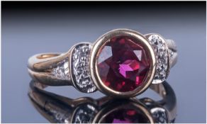 Ladies 9ct Gold Dress Ring, set with a central garnet between two rows of diamond chips. Fully
