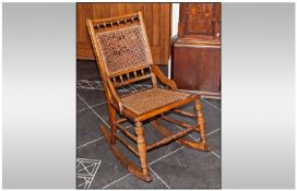 An Edwardian Cane Back and Seat Rocking Chair, in a beech frame.