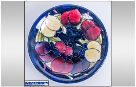 William Moorcroft Signed Shallow Footed Bowl, `Plums` pattern on blue ground. 7.5`` in diameter.