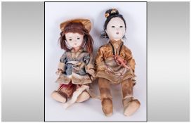 Two Chinese 1930`s Dolls comprising two girls, fully clothed  in contemporary silk outfits, wearing