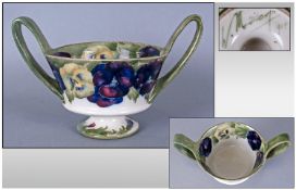 William Moorcroft Signed Twin Handle Footed Bowl, `Pansy` pattern. Reserved on green to white