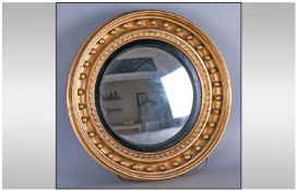 A Regency Convex Gilded Circular Mirror, of unusual size. In gilt frame, 19 inches in diameter.